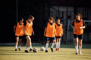 Female soccer players having sports training at the stadium.