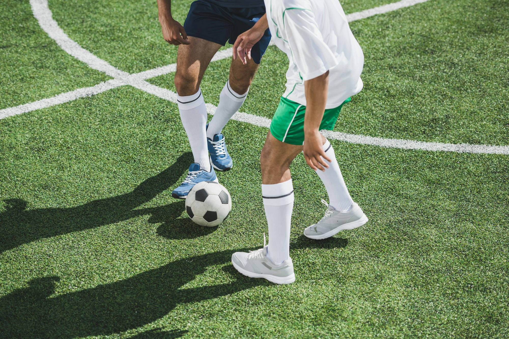 partial view of athletic soccer players playing soccer on pitch